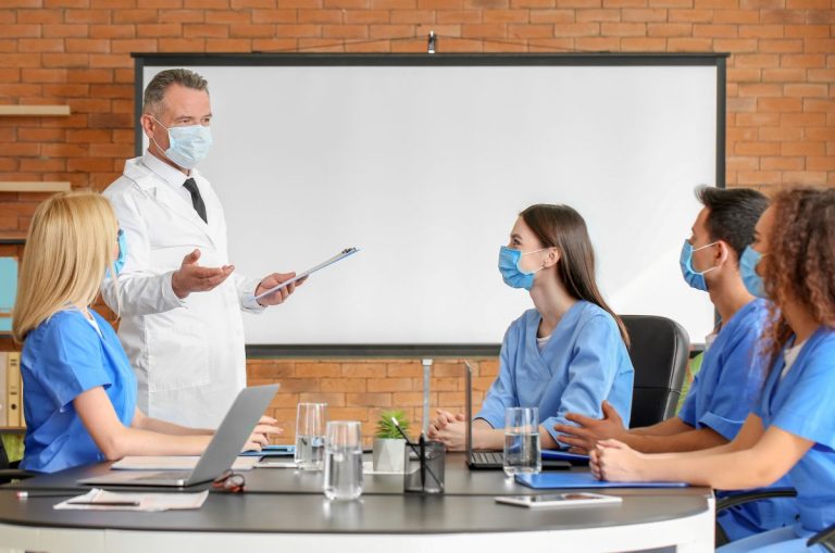Professor ministrando aulas para estudantes de medicina sobre prevenção de IRAS