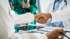 aperto de mãos da equipe médica ao se reunir com fornecedora