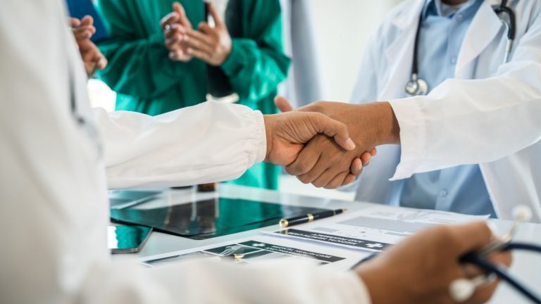 aperto de mãos da equipe médica ao se reunir com fornecedora
